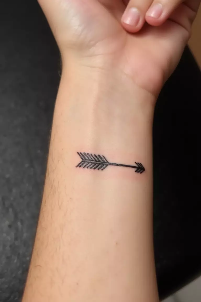 Small Wrist Arrow Tattoo A close up shot of woman's arm with a black ink small wrist arrow tattoo, delicate design perfectly positioned on the wrist