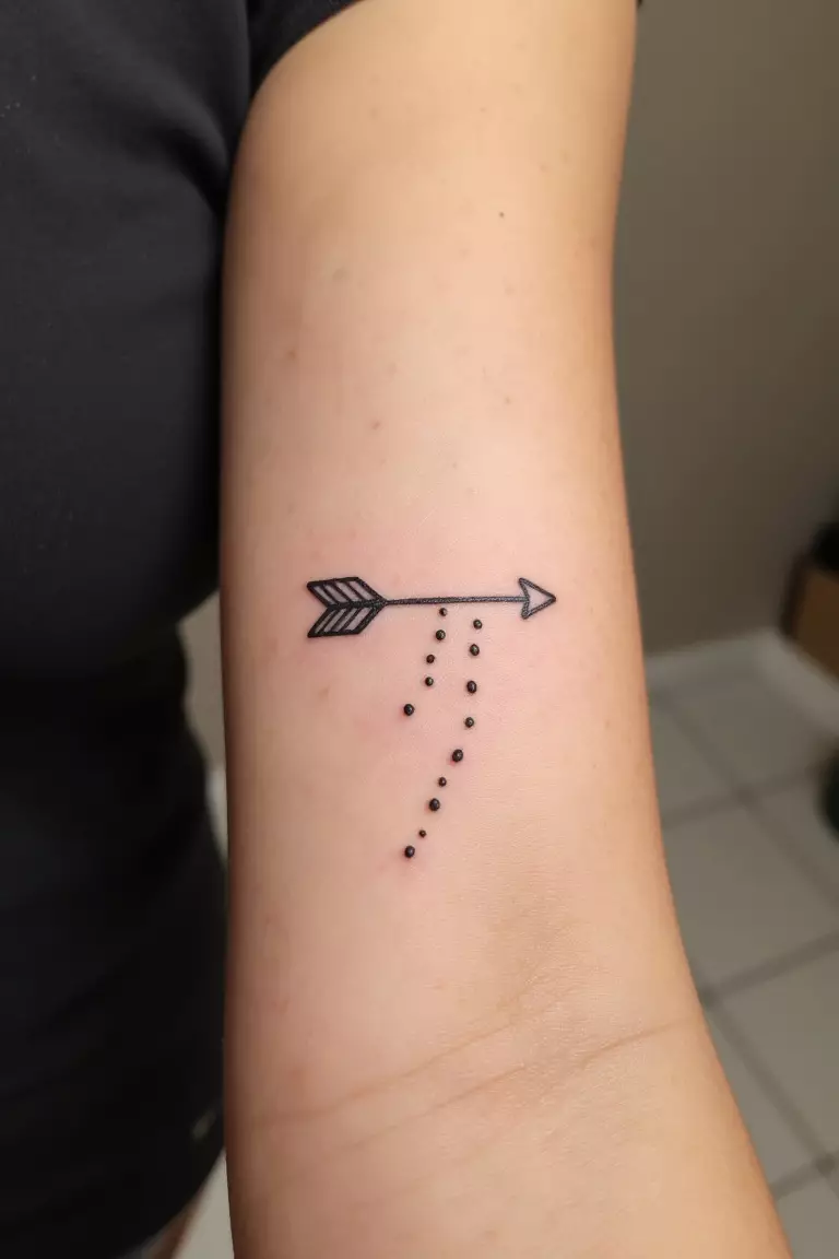 Minimal Arrow with Dots Tattoo A close up shot of woman's arm with a black ink minimal arrow with dots tattoo, simple arrow accompanied by a trail of dots