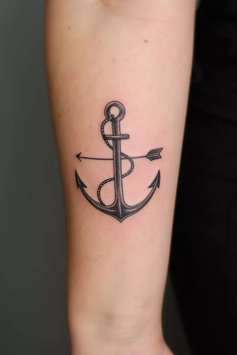 Arrow and Anchor Tattoo A close up shot of woman's arm with a black ink arrow and anchor tattoo, symbols combined to represent stability and direction