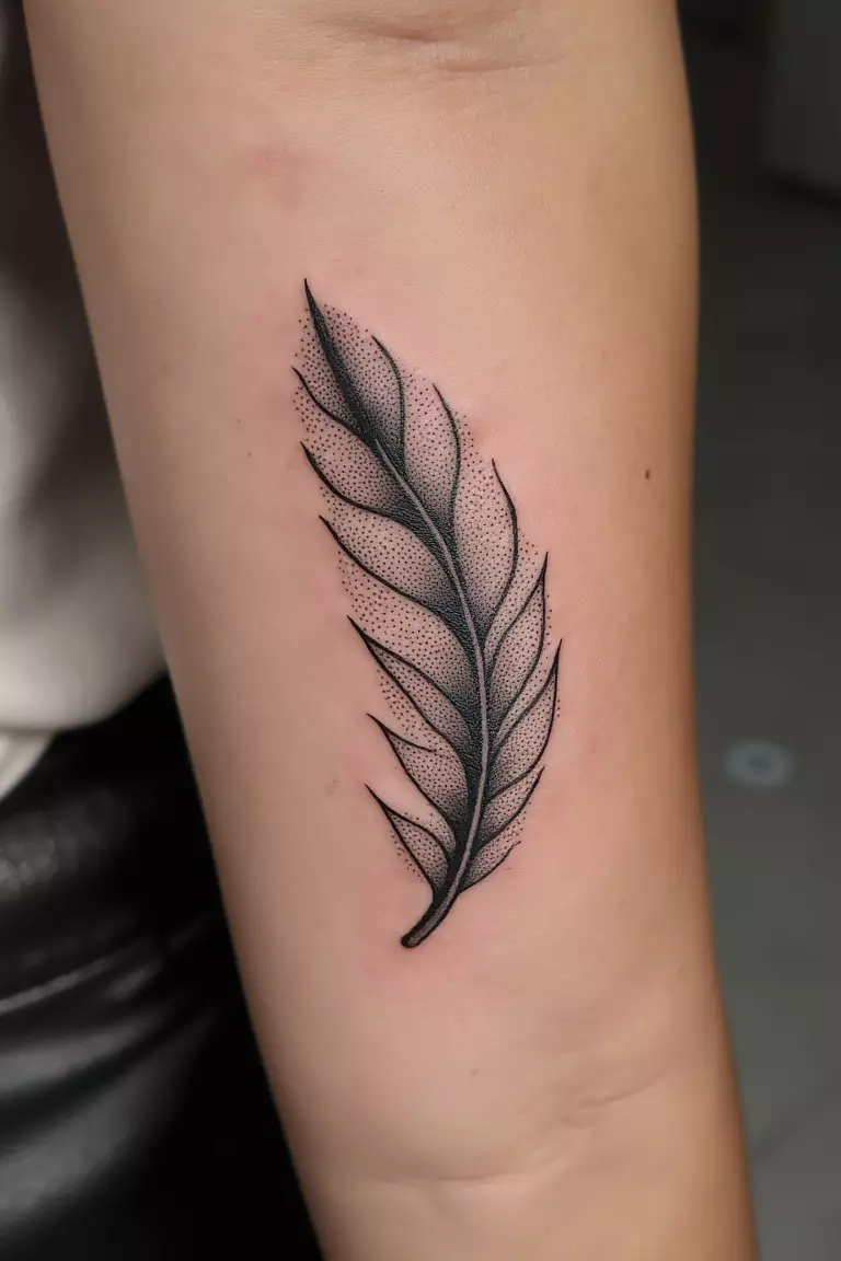 Stippled Feather Tattoo A close up shot of woman's arm with a black ink stippled feather tattoo, created entirely with tiny dots