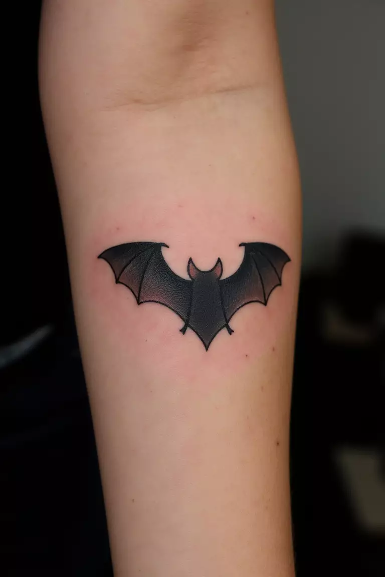 Detailed Bat Tattoo A close up shot of woman's arm with a black ink tattoo of a realistic bat.
