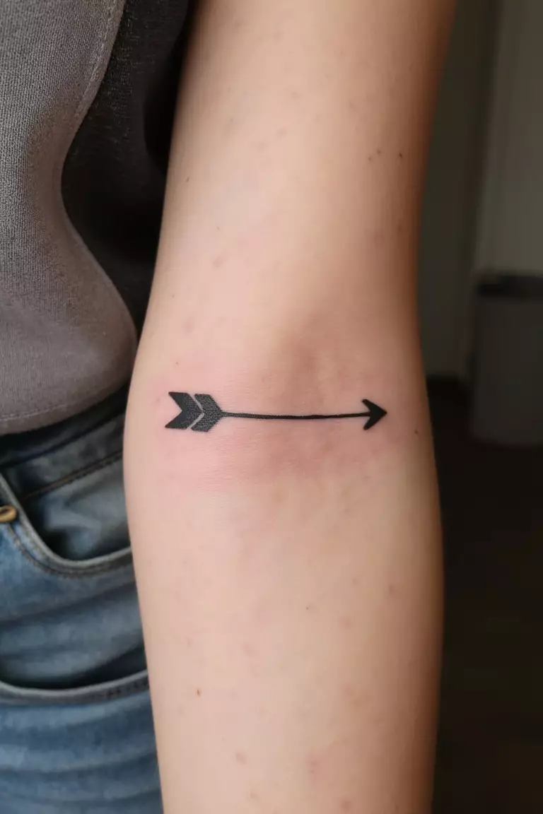 Single Arrow Tattoo A close up shot of woman's arm with a black ink single arrow tattoo, simple and elegant design, clean lines