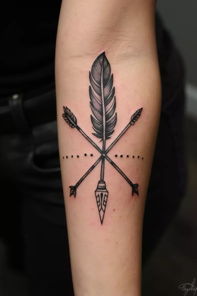 Feather And Arrow Design A close up shot of woman's arm with a black ink feather and arrow design tattoo, crossed elements with tribal details