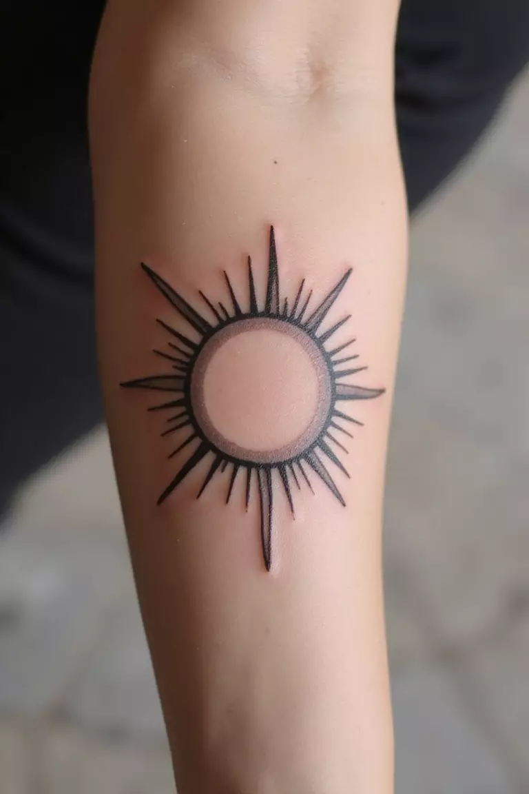 Minimalist Sun A close-up shot of a woman showing her black ink minimalist sun outline with simple rays tattoo design on her arm