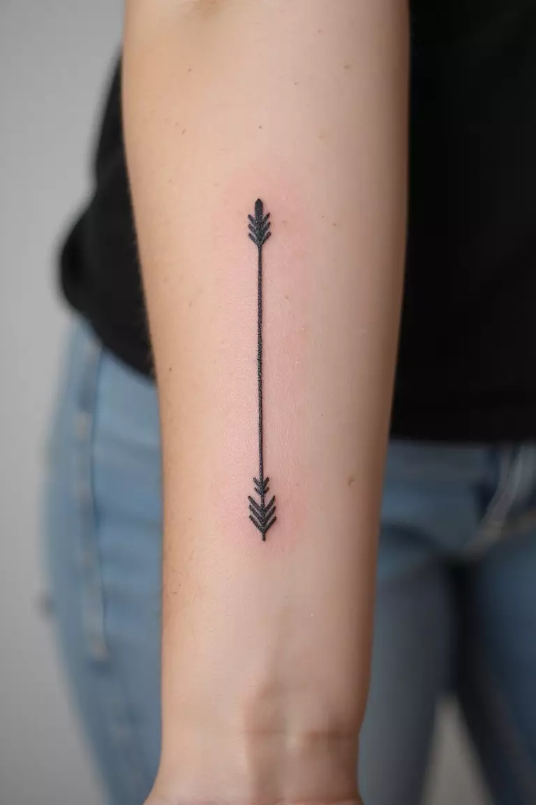 Subtle Arrow A close-up shot of a woman showing her black ink minimalist single arrow tattoo design on her forearm